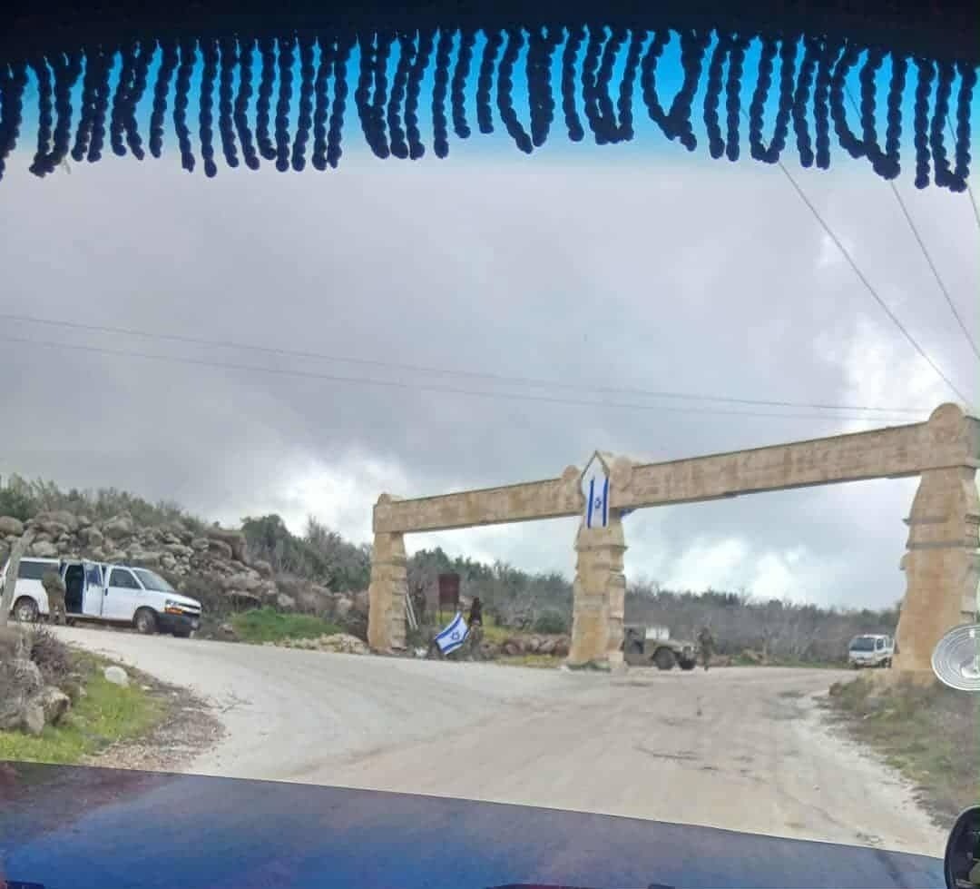 صورة ملتقطة من داخل إحدى السيارات المارة تظهر 
دورية تتبع للاحتلال الإسرائيلي أثناء رفع الأعلام