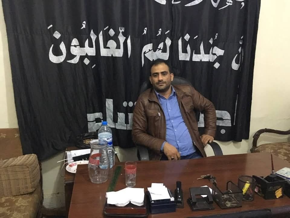صورة قيل إنها تعود لمحمد بلوات، يظهر فيها اسم "أجناد الشام" على يافطة في الخلفية.
