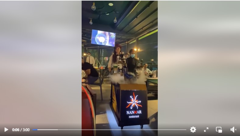 ظهور اسم المطعم على العربة التي تجرها النادلة التي تقدم الأركيلة بطريقة فنية في بغداد - العراق